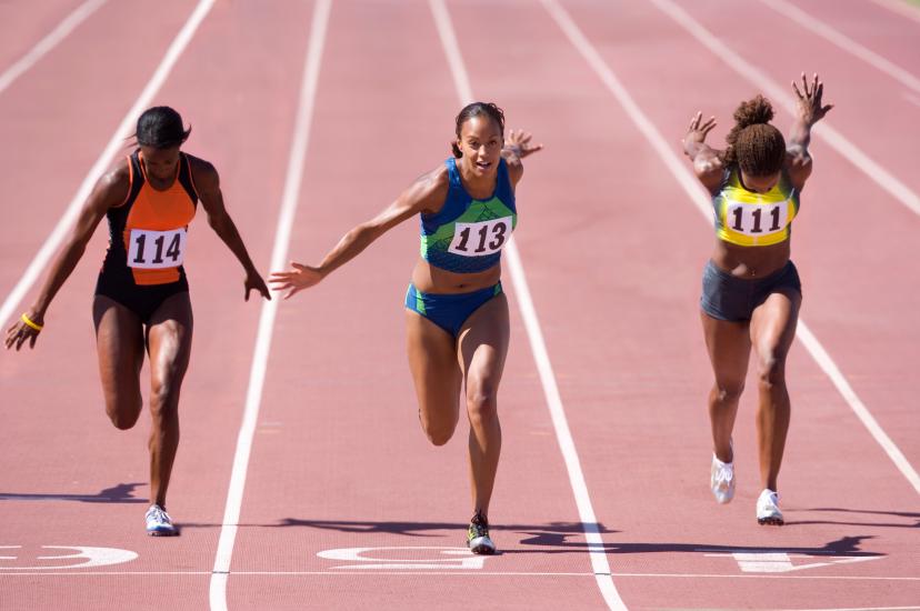 Female sprinters crossing the finish line