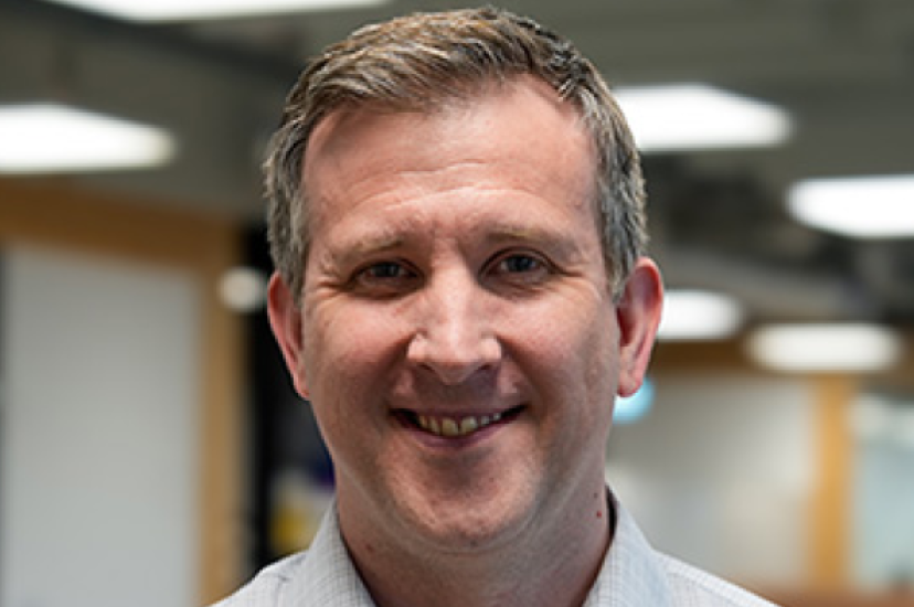 A white man with short hair in an office