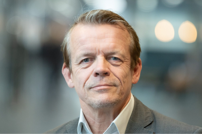 A white man with greying hair and wearing a suit
