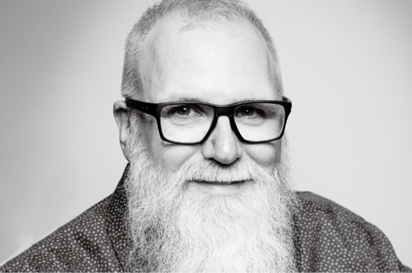 A white man with glasses and a large white beard