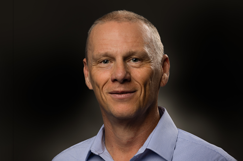 A white man with close-cropped hair and a blue shirt