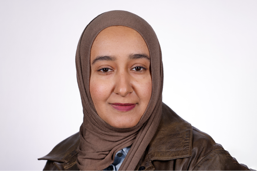 A Middle Eastern woman with brown eyes, is wearing a brown hijab and a brown leather jacket