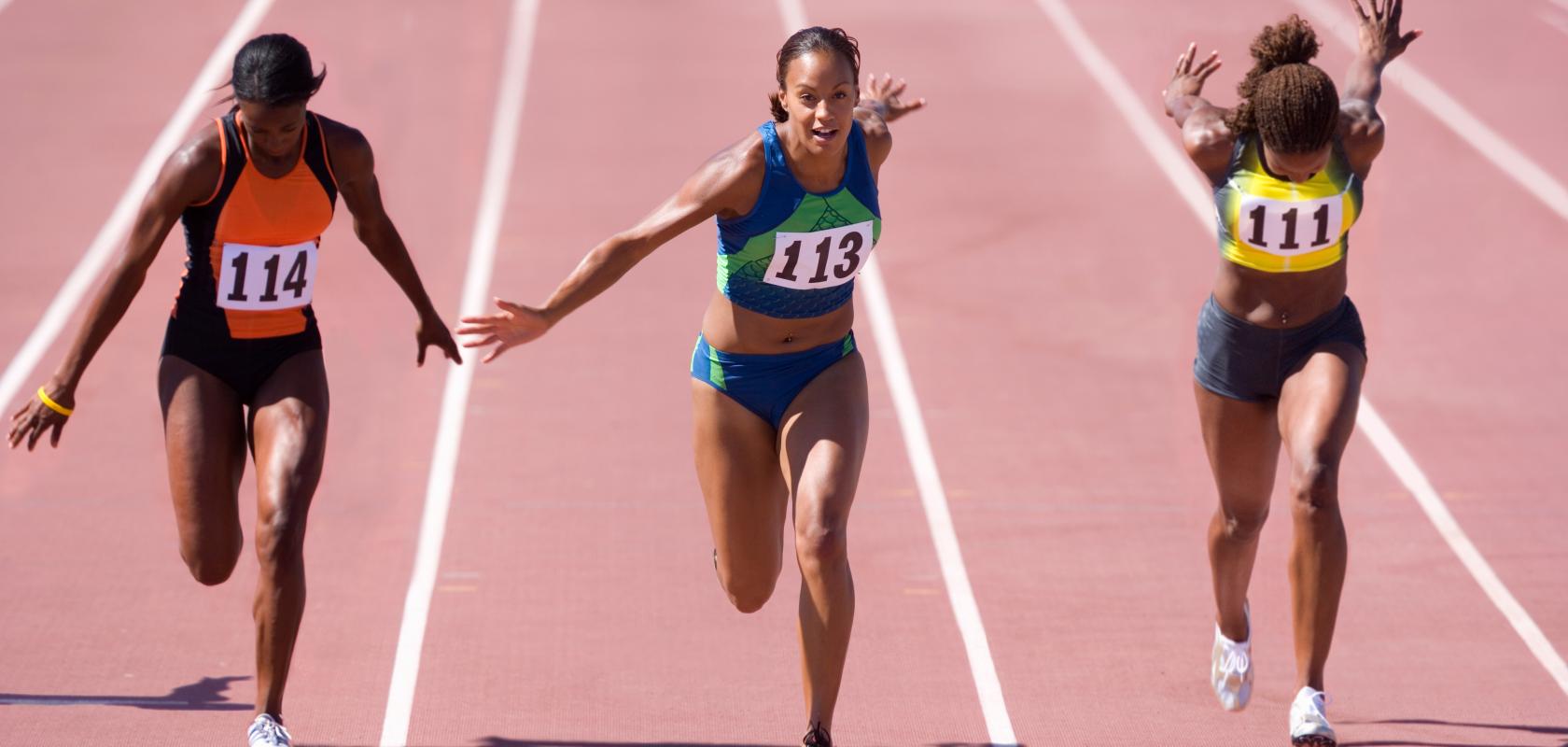 Female sprinters crossing the finish line