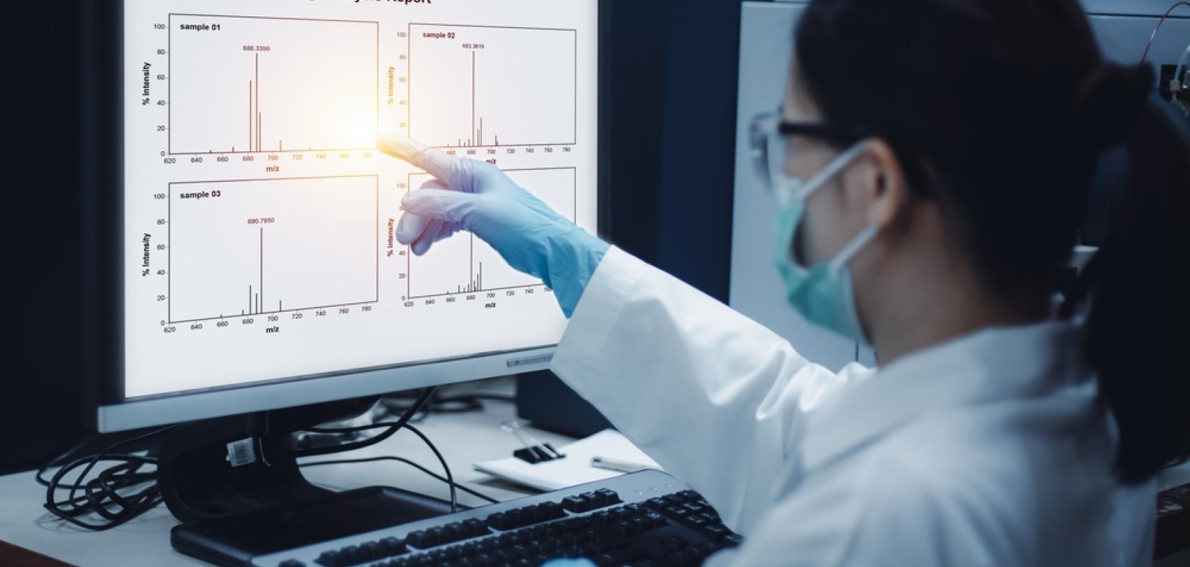 Mass spectrometry results are displayed on a screen.