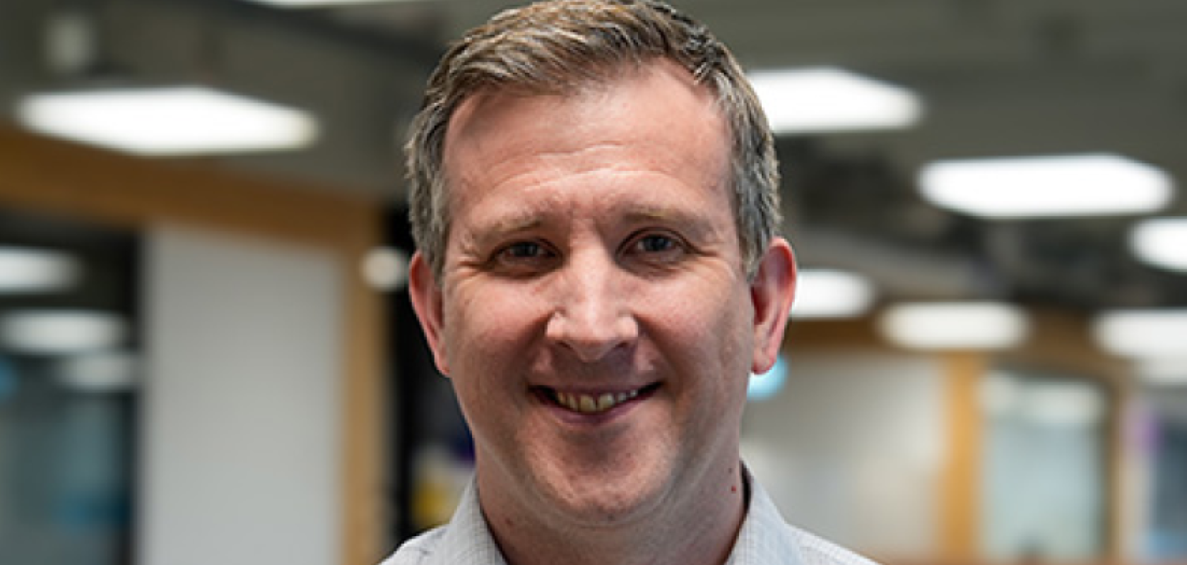 A white man with short hair in an office
