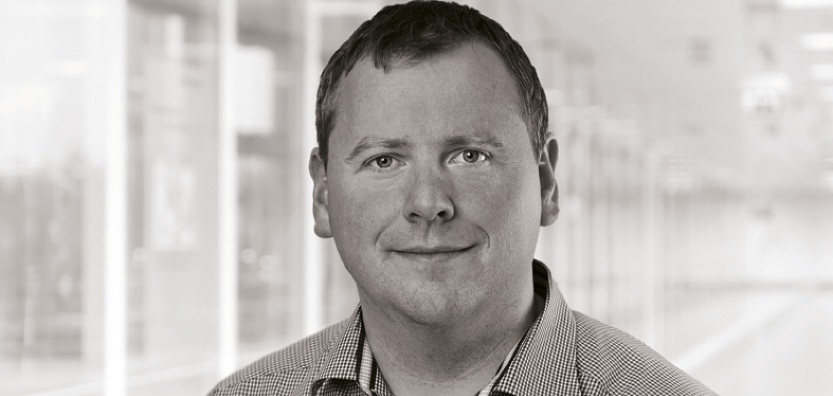 A mnochrome image of a white man with close cropped hair