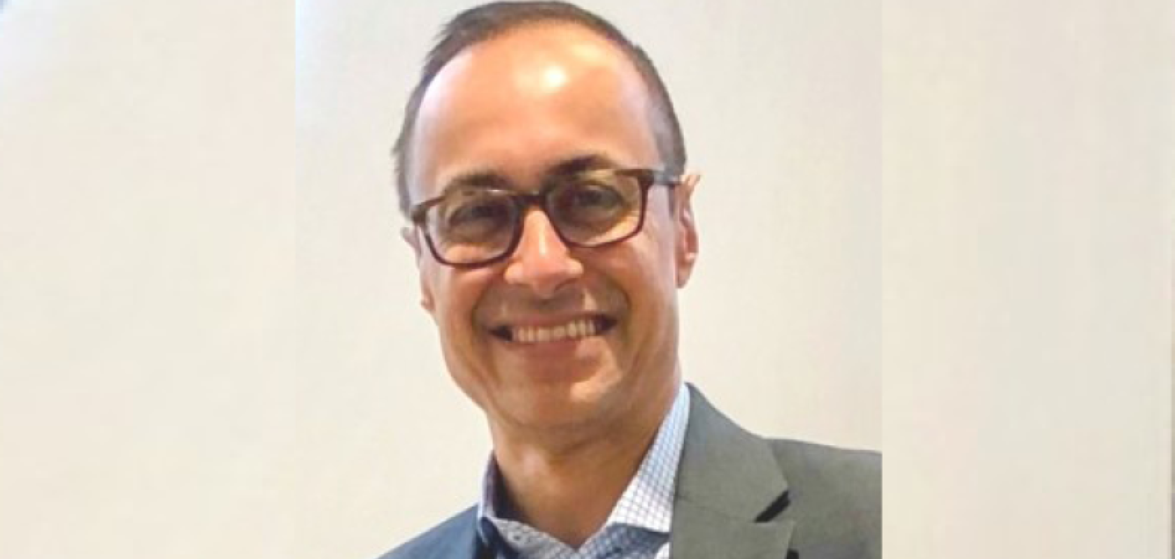 A man wearing glasses and a suit