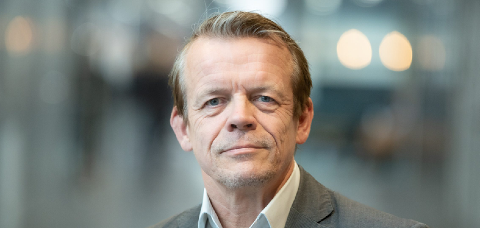 A white man with greying hair and wearing a suit