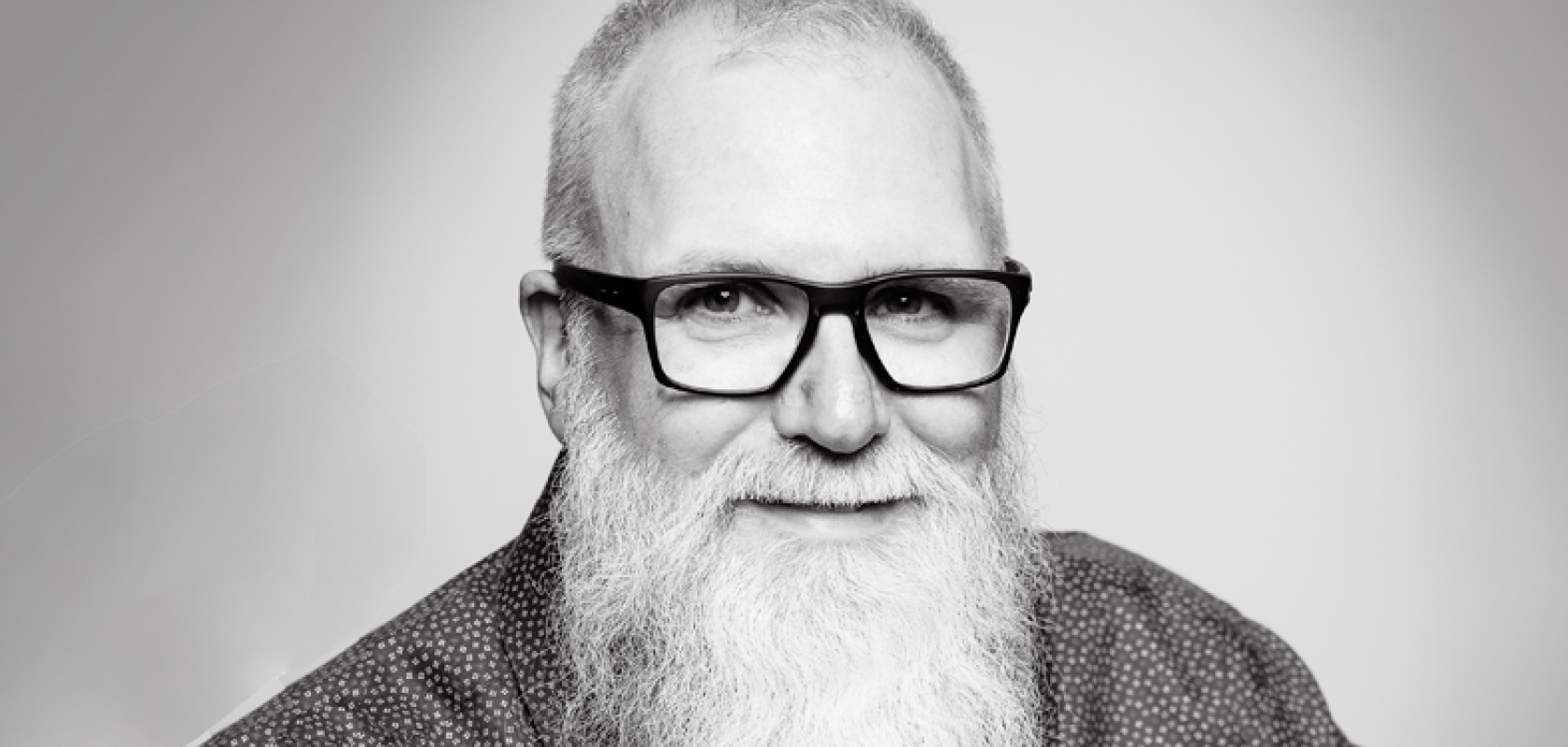 A white man with glasses and a large white beard