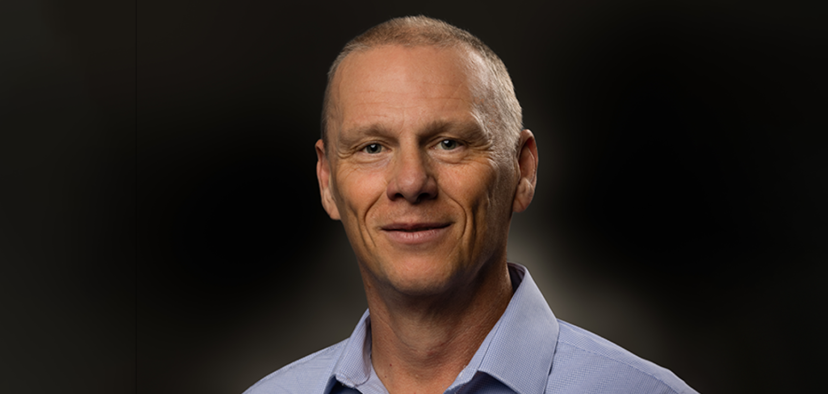 A white man with close-cropped hair and a blue shirt